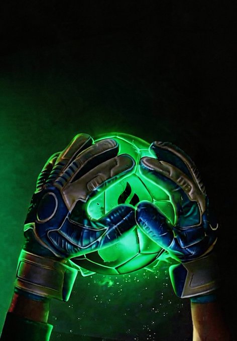 Two gloved hands clasp a glowing green soccer ball against a smoky dark background, evoking a goalkeeper's firm grip on a rising shot. The radiant green light symbolizes the "save" mindset, visually reinforcing the post's message of switching from scoring goals to blocking them.
