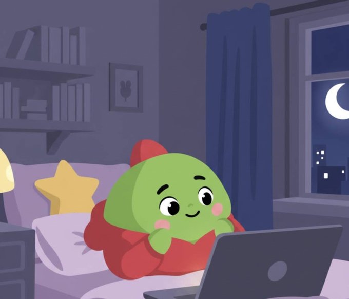 An illustration of a cute green character with a red hood lying in bed under a star-shaped pillow, using a laptop at night with a crescent moon visible through the window.