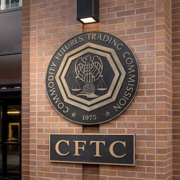 A circular emblem and plaque for the "Commodity Futures Trading Commission" (CFTC), established 1975, mounted on a brick building. The image relates to the post by visually representing the federal agency whose vacant commissioner seats the White House is reportedly working to fill.