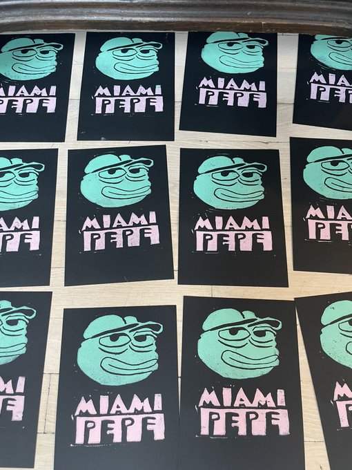 Multiple identical black stickers featuring a green Pepe the Frog character wearing a cap and glasses, with 'MIAMI PEPE' text printed in pink, arranged in rows on a surface.
