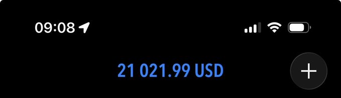 A smartphone status bar showing the time 09:08 with an arrow icon, signal strength, Wi-Fi, and battery indicators, above a balance of "21 021.99 USD" in blue text with a "+" button. The image relates to the post by displaying the user's remaining account balance of just over $21,000 USD, suggesting progress toward an $80,000 goal.
