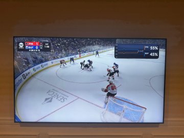 A television displays a hockey video game with Polymarket live odds overlaid in the upper-right corner, including visible percentages such as “55%” and “45%,” alongside a “FORZA” logo on the ice. The image illustrates the post’s claim that the odds appear as a picture-in-picture overlay on Apple TV over YouTube TV.