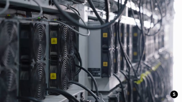 A close-up view of server racks with cooling fans and network cables in a data center.