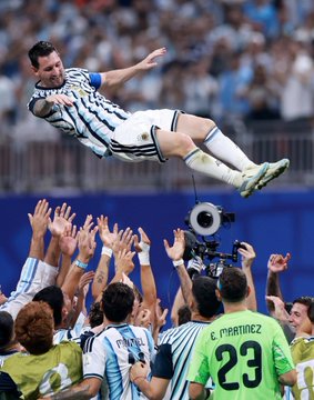 Argentina's captain, wearing the iconic #10 jersey, is dramatically tossed into the air by jubilant teammates—including "MARTINEZ 23" on his green training bib—after a commanding performance against Egypt, capturing the emotional peaks and valleys of a match that mirrors the volatility of trading.