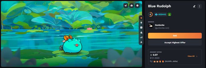 The image features a cartoon character sitting by a body of water with a green background. The character appears to be a small fish or frog-like creature, possibly a blue Rudolish. The text "Blue Rudolish" can be seen in the image, which is related to the post that says "One day, I'll get one of them Mystic Axie. For now, I'll settle for this good boi."