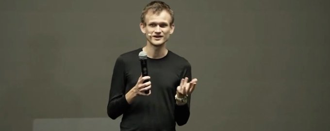 Vitalik Buterin, co-founder of Ethereum, giving a presentation on stage while wearing a headset microphone and gesturing with his hands.