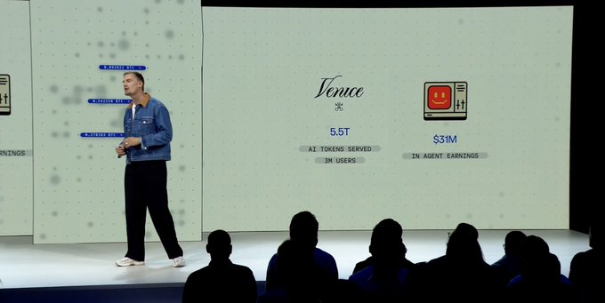 The image shows a man standing on stage, giving a speech or presentation. There are several people sitting in chairs behind him, attentively listening to his words. The background of the scene features a white wall with various logos and text, including one that reads "Vena" and another that says "9.57M". Additionally, there is a post on social media that includes a coinbase roadmap for a new project.