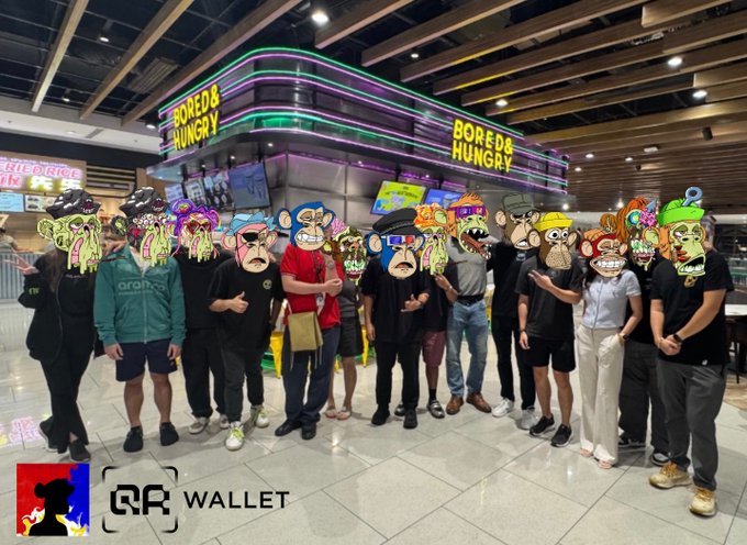 A group photo from a Baykada meetup with QR Wallet, showing attendees posing in front of a "Bored & Hungry" restaurant, with QR Wallet branding visible. The post celebrates that attendees learned they can now purchase anything in the Philippines using $APE through QR Wallet, teasing future meetups.
