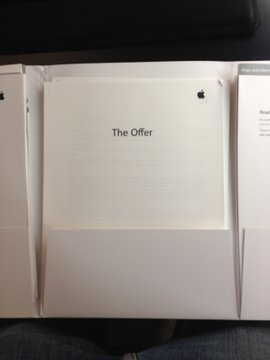 A photograph shows the top page of a legal document titled "The Offer," with the Apple logo in the corner, partially obscured by other paperwork.

The image relates to the post by humorously highlighting the absurdity of Apple being involved in a tangible paper offer in an increasingly digital world.
