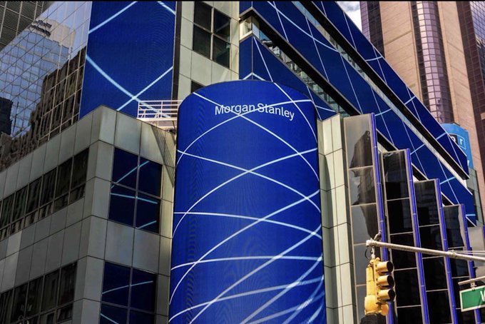 Photograph of a Morgan Stanley building featuring a large blue digital facade with white curved line graphics and the Morgan Stanley name displayed at the top.
