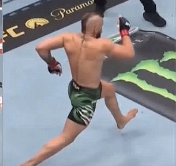 A UFC fighter runs across the octagon mat near a "Paramount" logo and green Monster Energy branding, with the post's caption "Time to force a sui season" appearing to humorously anthropomorphize the running fighter as being in a frantic, panicked state—poking fun at the fighter's mid-fight rush by likening it to a desperate "suicide season" moment.