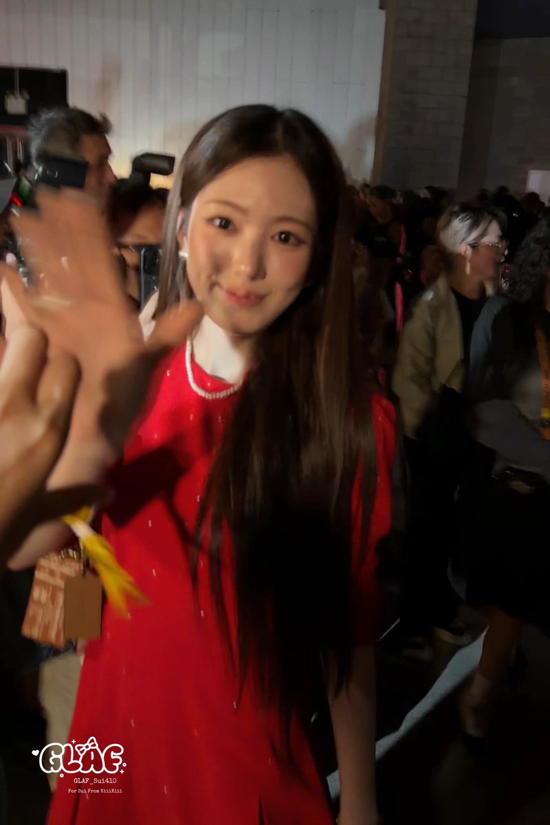 A young woman with long dark hair wearing a red dress with pearl detailing waves at the camera in a crowded indoor venue, with a 'GLAC' watermark dated '9월14일' at the bottom.