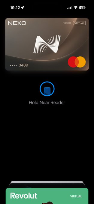 A smartphone screenshot showing a digital NEXO credit card in Apple Wallet with the prompt to "Hold Near Reader," with a Revolut virtual card visible at the bottom.