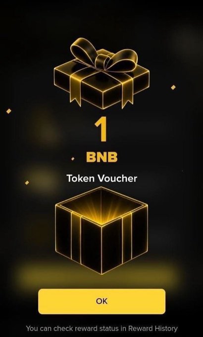 A digital reward screen displaying a golden gift box and a "1 BNB Token Voucher" with an "OK" button, celebrating Binance's 9th anniversary promotion. The text at the bottom reads, "You can check reward status in Reward History."