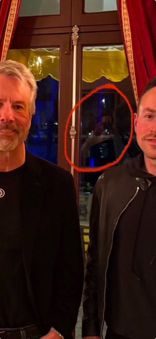 idsk, a person who posted the picture, has tagged a post about a game called "The Roaring Kitten" with a caption that reads "idk still convinced @TheRoaringKitty took this photo tbh $GME GameStop". The image features two men standing in front of a window.