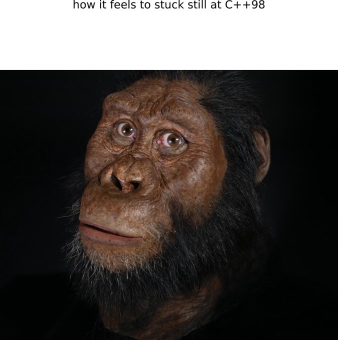 A close-up image of a realistic ape/early hominid reconstruction with the caption "how it feels to stuck still at C++98".