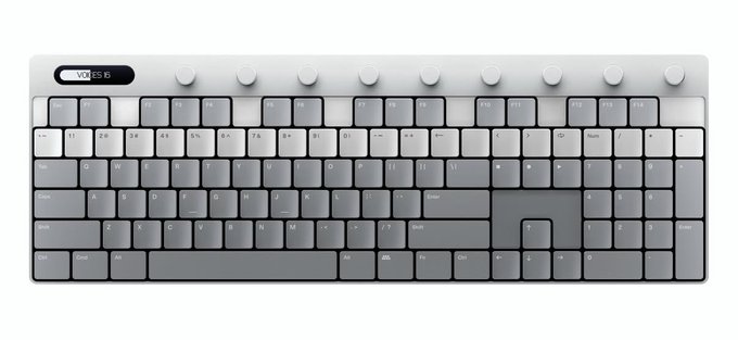 The image shows a sleek silver and black mechanical keyboard with rotating dials along the top and a small digital display reading "VOL ES 16". The caption playfully connects to the post about an uncontrollable wallet by suggesting that the temptation of this premium, feature-packed keyboard might trigger an impulse buy that the buyer can't resist—much like their wallet moving on its own.