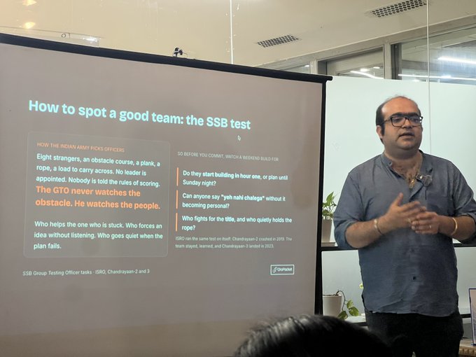 A presenter stands next to a projection titled "How to spot a good team: the SSB test," which references an article on "How the Indian Army picks officers."