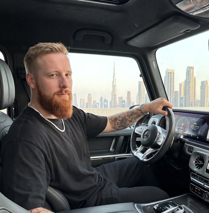 A bearded, tattooed man sits behind the wheel of a luxury Mercedes SUV with a city skyline visible through the window, projecting an image of success. The caption aligns with the post's optimistic "Good morning future $SOL millionaires" message, suggesting crypto wealth has enabled the lavish lifestyle shown.