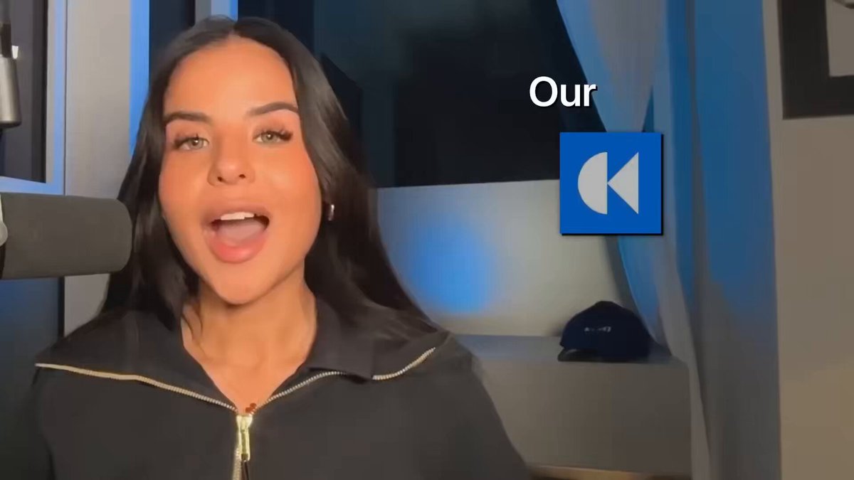 The image features a woman with long brown hair wearing a black jacket who appears to be smiling at the camera. The background of the photo shows a window that has a blue curtain, suggesting an indoor setting. There are also some text elements in the image, including "Our" and "CLEO AI CROSSED $60,000 MRR IN LESS THAN 2 MONTHS AND JUST BECOME THE NEW BLUEPRINT FOR B2B SAS LAUNCHES". The woman's presence in front of the window adds a sense of depth to the image.