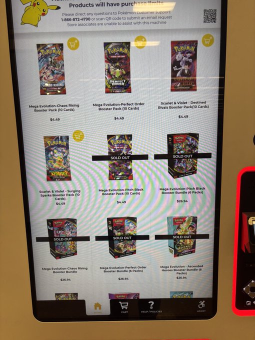 A photograph of a digital screen displaying the Pokémon Center website store, showing various 'Mega Evolution' booster packs like 'Chaos Rising', 'Perfect Order', and 'Destined Rivals' for $4.49, with several items marked as 'SOLD OUT'.