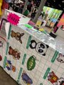 A blurry photo of a bulletin board displaying colorful children's artwork and papers in a hallway setting.