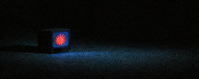 An old CRT television sitting in a dark room displaying a bright red and yellow starburst or explosion image on its blue-tinted screen.