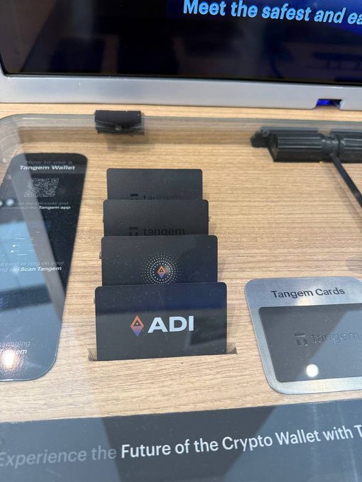 ADI Chain and Tangem cold storage wallets are showcased in UAE Virgin Megastores, with plans for a global expansion. The image displays these Tangem Cards, including one branded with "ADI".