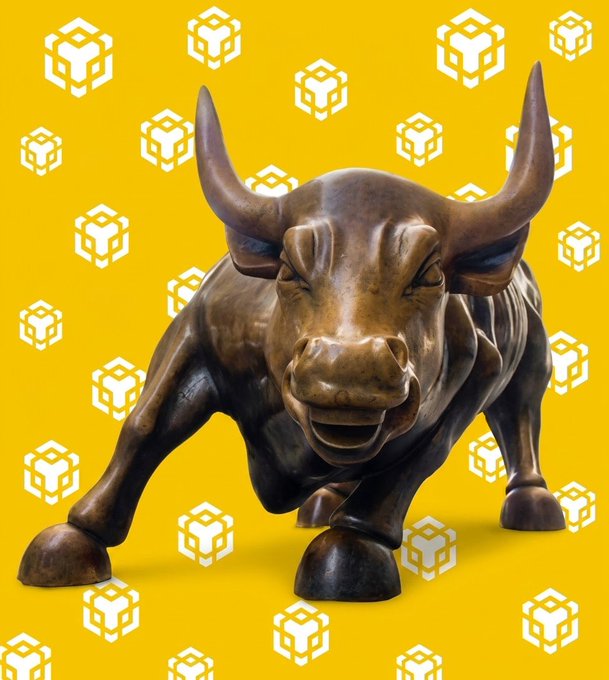 The image features a bronze statue of a bull with horns, standing against a yellow background adorned with white cubes. The caption reads "NEWS: @vaneck_us debuts the first U.S. spot $BNB ETF". This suggests that the image is related to an ETF or investment fund called BNB (Bullionary New Bull) and it has been launched in the United States, possibly as a part of the Vanguard Group's offerings.