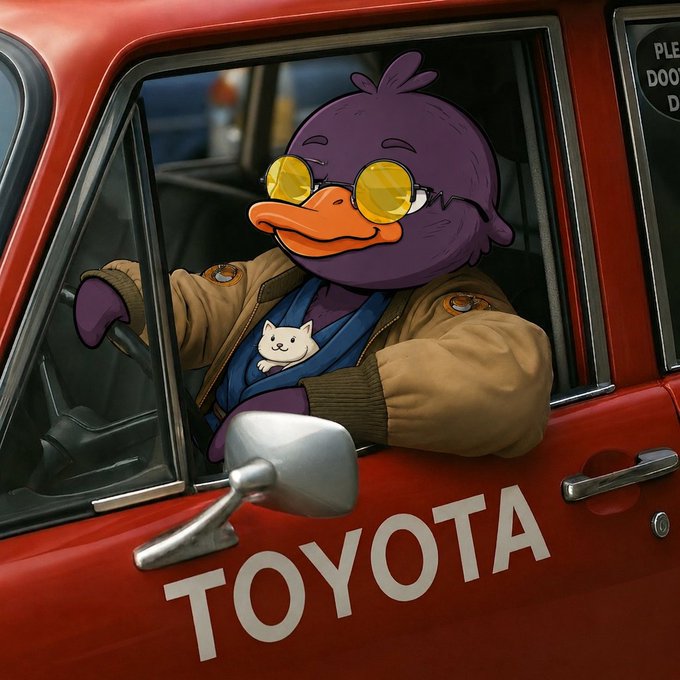 The image features a cartoon duck sitting inside of a red car, wearing sunglasses and holding onto a steering wheel. The car has a Toyota logo on its side, indicating that it might be a toy or a promotional vehicle for the brand. The scene is set in an urban environment with buildings visible through the window of the car.

The image also contains text elements such as "@quipnetwork" and "@quiptimelines", which could possibly be related to the content being posted on social media platforms, news websites or other online sources. Additionally, there are mentions of "focus on what is in the image and how it relates to the post". This suggests that the image might be a part of a larger discussion or conversation about a specific topic or event.