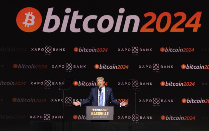 Donald Trump speaks at a podium at the 'Bitcoin 2024 Nashville' conference, with a backdrop displaying the Bitcoin logo and 'Xapo Bank' logos.