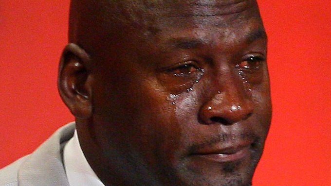 A close-up photograph of basketball legend Michael Jordan with tears visibly streaming down his face against a red background.