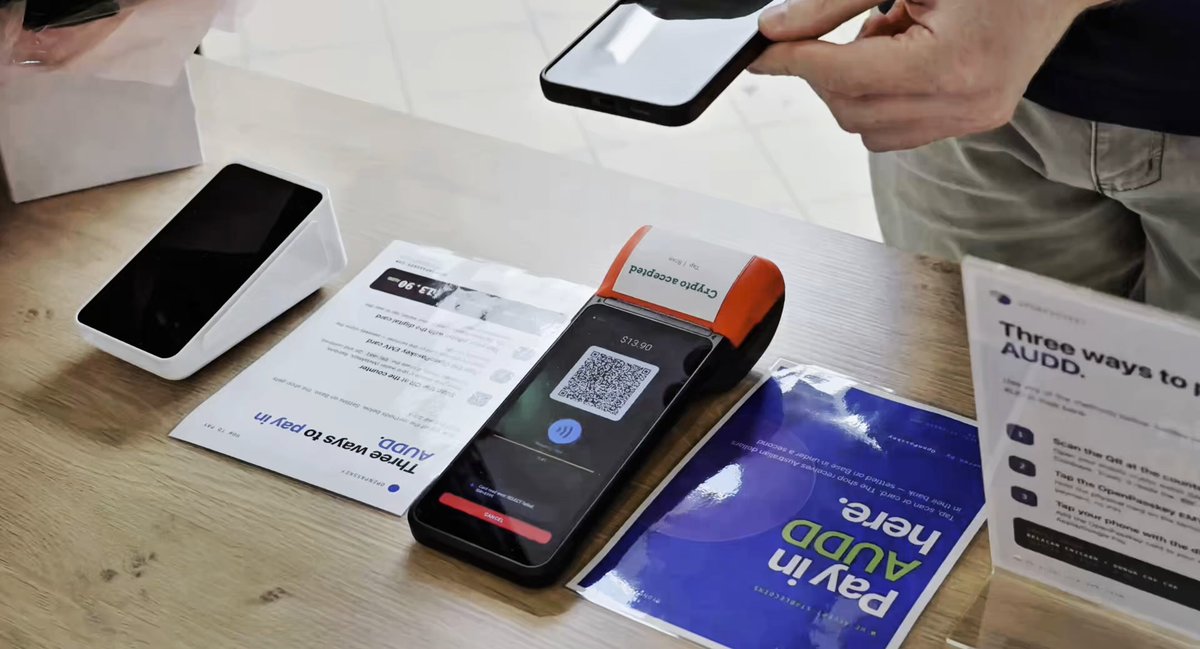 The image shows three people standing around a table with various electronic devices such as smartphones, credit cards, and payment methods. One person is holding a smartphone while another person is using a credit card at an ATM or similar device. The third person appears to be looking at a paper that contains information about the electronic devices on display. The scene suggests that these individuals are discussing or demonstrating how to use the different electronic devices available for transactions and payments, possibly related to the post's content about Audible payment methods.
The image also includes text elements such as "3 people. 10 months. No outside funding. We registered our own IIN, wrote our own EMV terminal software, and settled real payments on @base at a real shop." This information is likely related to the electronic devices being showcased in the scene.