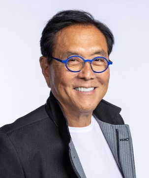 A smiling older man with dark hair wears distinctive bright blue round eyeglasses and a dark jacket over a white shirt. The image accompanies Robert Kiyosaki's bold prediction about an imminent historic market crash and Bitcoin's rise to $750,000, visually representing the financial commentator known for his unconventional investment forecasts.