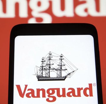 A smartphone screen shows the “Vanguard” name in red beneath an illustration of a sailing ship, with large blurred white text in the red background above.