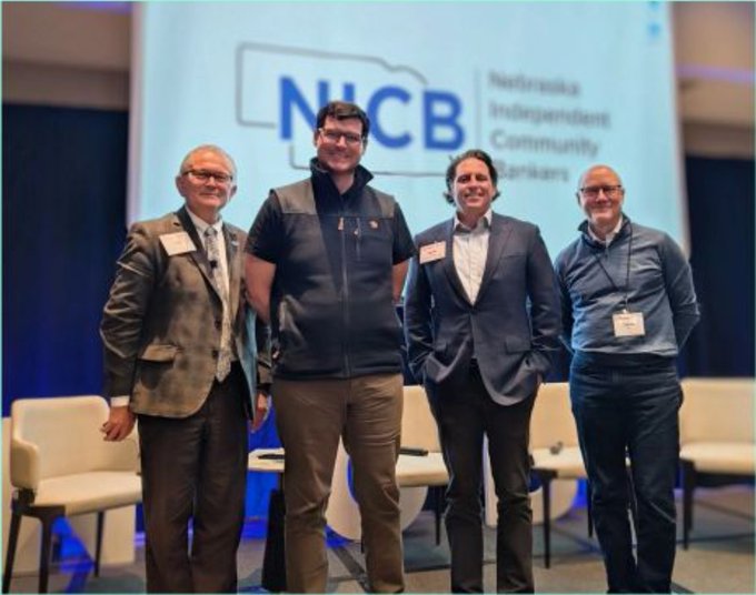 Four men in business attire pose together at a Nebraska Independent Community Bankers (NICB) conference.