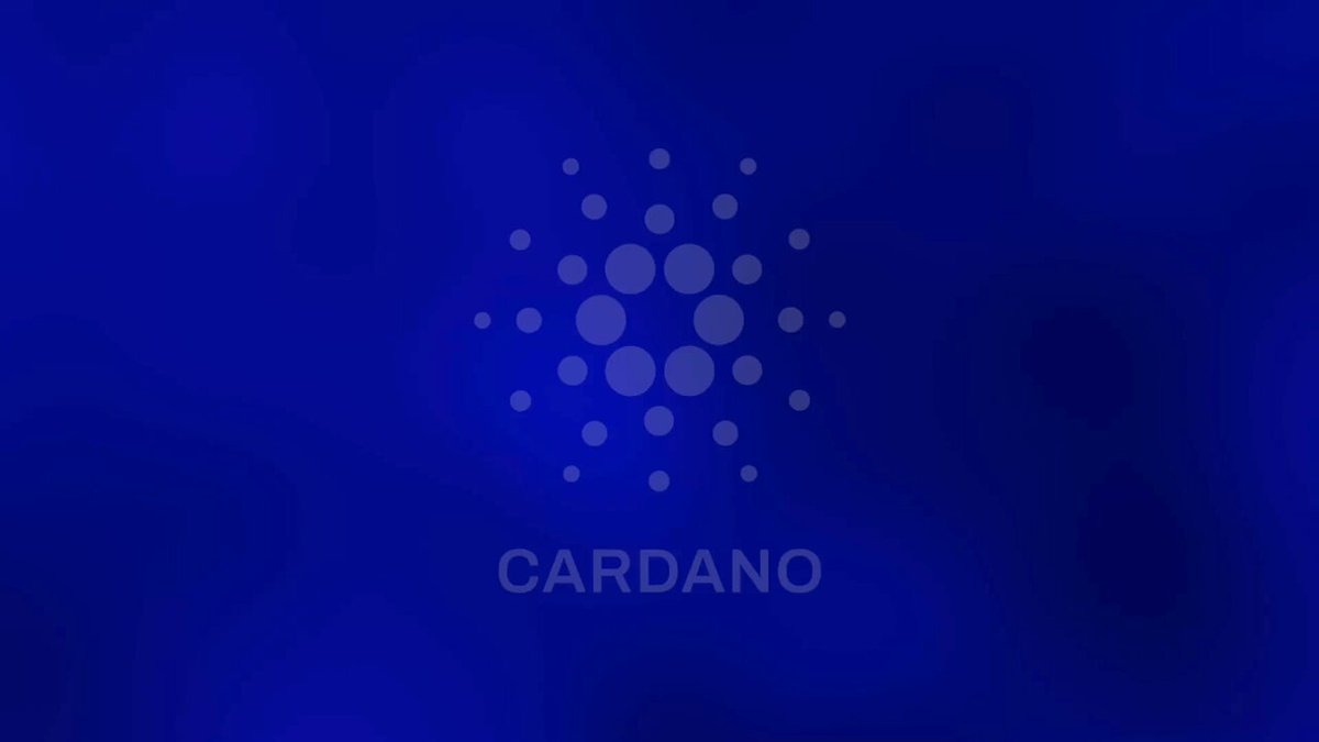 The image features a large graphic with a dark blue background, outlined in white, that prominently displays the logo of "Cardano" in white letters against the blue backdrop. The text "Love this! And we need this!" is written below the logo, possibly emphasizing the importance or appeal of the Cardano cryptocurrency.