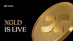 The image features a gold coin with the letters "XLGD" written on it, which is the main focus of the picture. The background of the image is black, making the gold coin stand out prominently. Below the coin, there's text that reads "XLGD IS LIVE", indicating that the coin is currently active and in use.