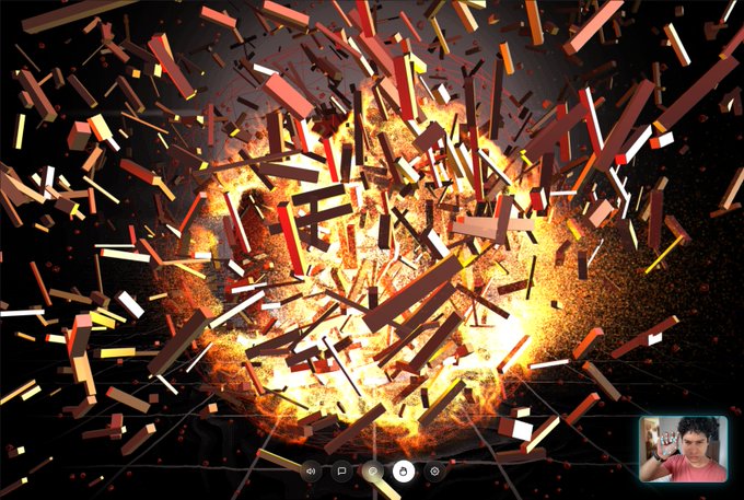 A video player screenshot showing a dramatic 3D explosion of shattering fragments with fire, with a small webcam feed of a person in the bottom right corner.