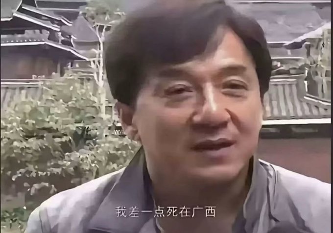 Jackie Chan is shown in an outdoor interview setting, with a Chinese subtitle reading "我差一点死在广西" ("I almost died in Guangxi"), referencing the post's mention of an incident in Guangxi.
