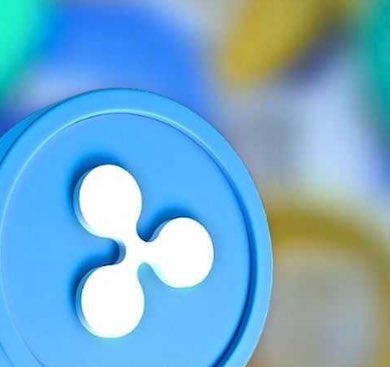 A close-up of a blue Ripple (XRP) physical cryptocurrency token (altcoin) featuring the three-circle logo.