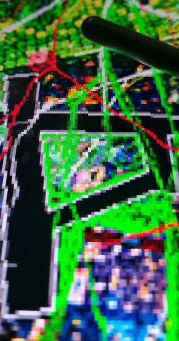 A close-up view of a digital map on a tablet or screen, with a stylus pen pointing at a highlighted green area showing colorful data points.