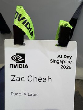 A name badge for "Zac Cheah" from "Pundi X Labs" is displayed alongside NVIDIA AI Day Singapore 2026 branding, tied with a bright neon green NVIDIA lanyard. The badge confirms Zac Cheah's attendance at the event, aligning with the post about loading up Pundi X Basket and showcasing the HeyNemoAI AI coworker at NVIDIA AI Day Singapore.