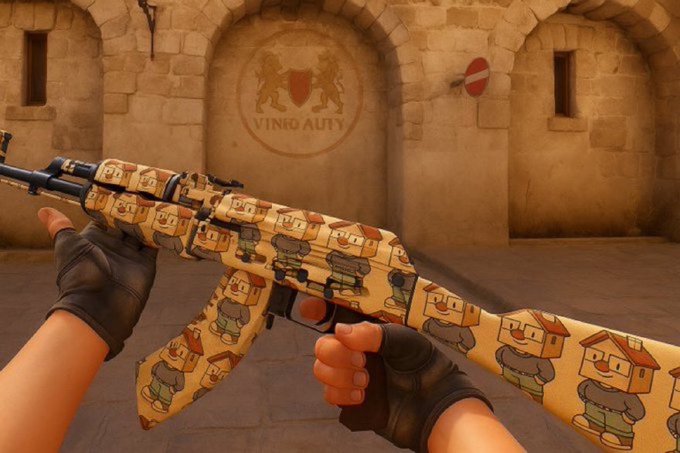 First-person view from a video game showing gloved hands holding an AK-47 rifle decorated with a cartoon character skin, in a stone courtyard setting.