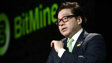 A man in a dark suit with a green tie stands at a podium with the "BitMine" logo displayed on a screen behind him, appearing to be speaking at a corporate event for the Kabam-related BitMine Immersion Technologies. The green and black branding suggests a focus on cryptocurrency or mining technology, with the speaker's formal attire and confident posture indicating a professional presentation setting.