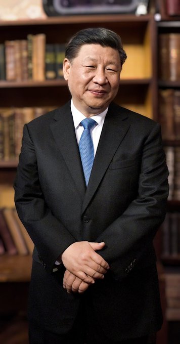 This image features Chinese President Xi Jinping standing with his hands clasped in front of a bookshelf, dressed in a formal black suit and blue tie, which aligns with the accompanying text regarding China's push for a nationwide blockchain network and strengthening its digital infrastructure.