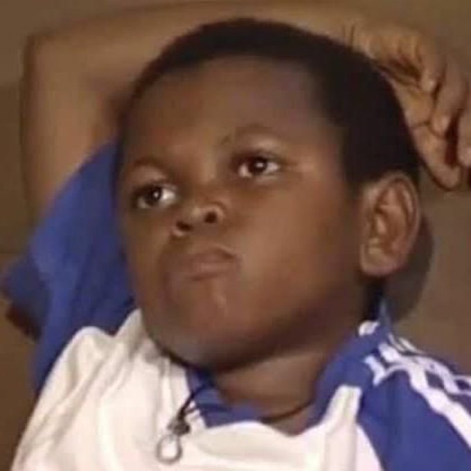 A young boy with a skeptical, unimpressed expression lies with his arm behind his head, staring off to the side. His doubtful look perfectly matches the post's teasing question in Nigerian Pidgin, capturing the feeling of skepticism toward someone's repeated failed promises.