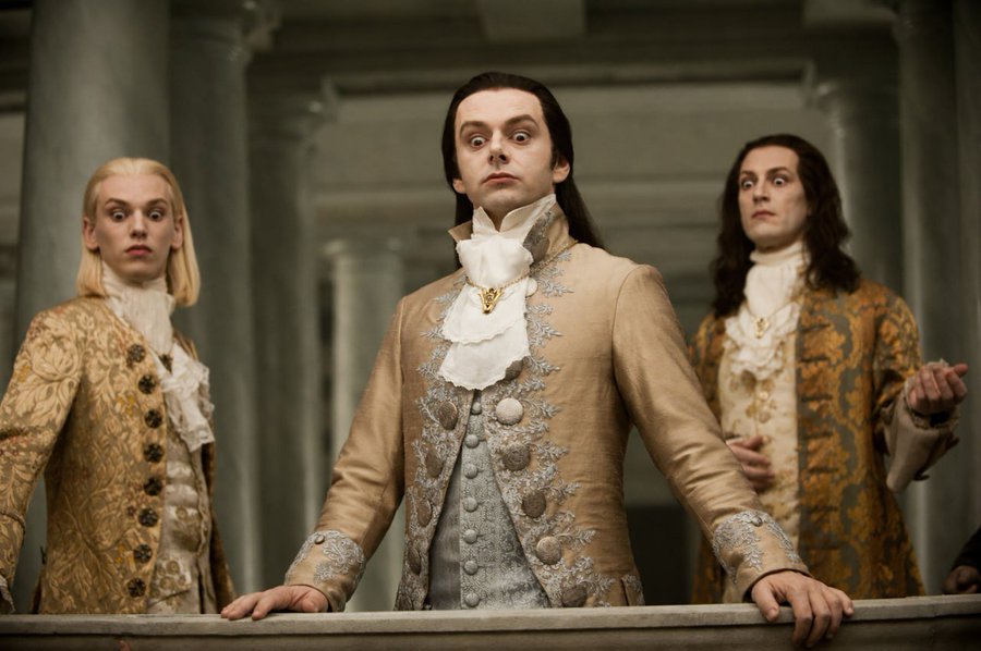 Three pale, dark-haired aristocrats with wide-eyed, startled expressions stand in an ornate hall wearing elaborate 18th-century brocade coats, evoking the bewildered, stunned traders watching the $TOWNS chart with bated breath.