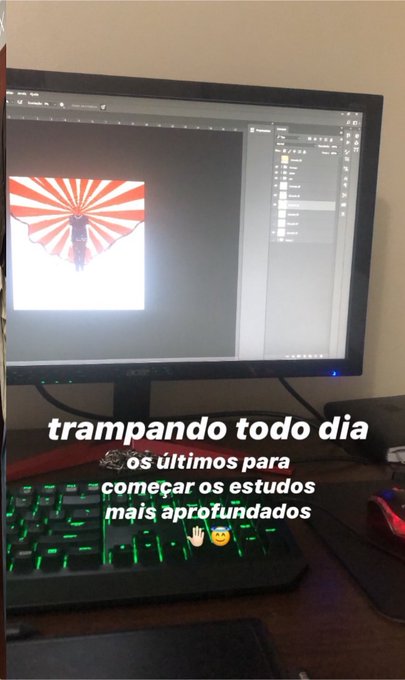 A vertical photo of a computer monitor displaying an image editing software with a red sunburst graphic, accompanied by Portuguese text: 'trampando todo dia os últimos para começar os estudos mais aprofundados'.