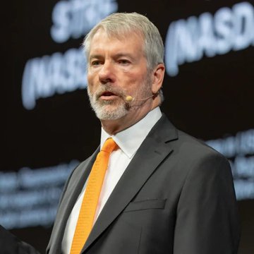 In this image, there is an older man wearing a suit and tie standing in front of a large screen or projector that displays information about Michael Saylors. The man appears to be giving a speech or presentation related to Bitcoin, as indicated by the text "Bitcoin is money, we want to acquire the Bitcoin". The focus on this image suggests that it could be an advertisement or promotional material for Bitcoin or a similar cryptocurrency project.

The man's attire and the context of his speech imply that he might be a speaker at an event or conference related to Bitcoin or blockchain technology. His goal is likely to educate, inform, or inspire others about the potential benefits and opportunities associated with Bitcoin and other cryptocurrencies.